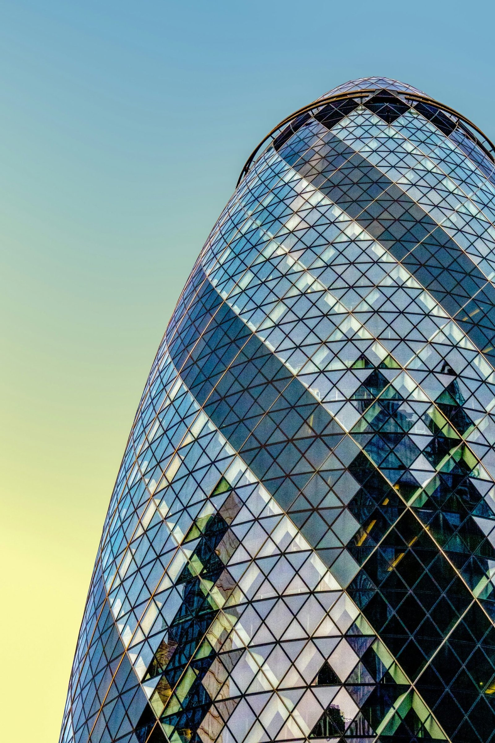 a very tall glass building with a clock on it's side